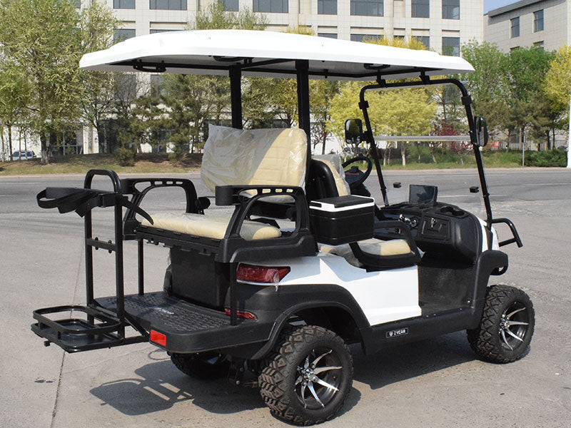 White and black golf cart on a paved road with trees and buildings in the background