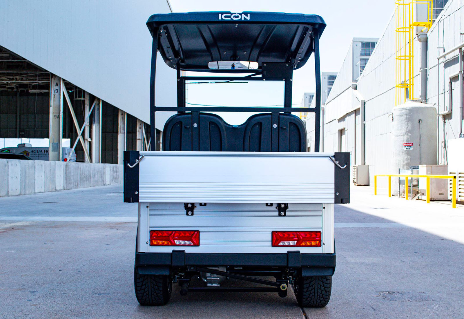 Back view of a small utility vehicle with 'ICON' branding in an industrial setting.