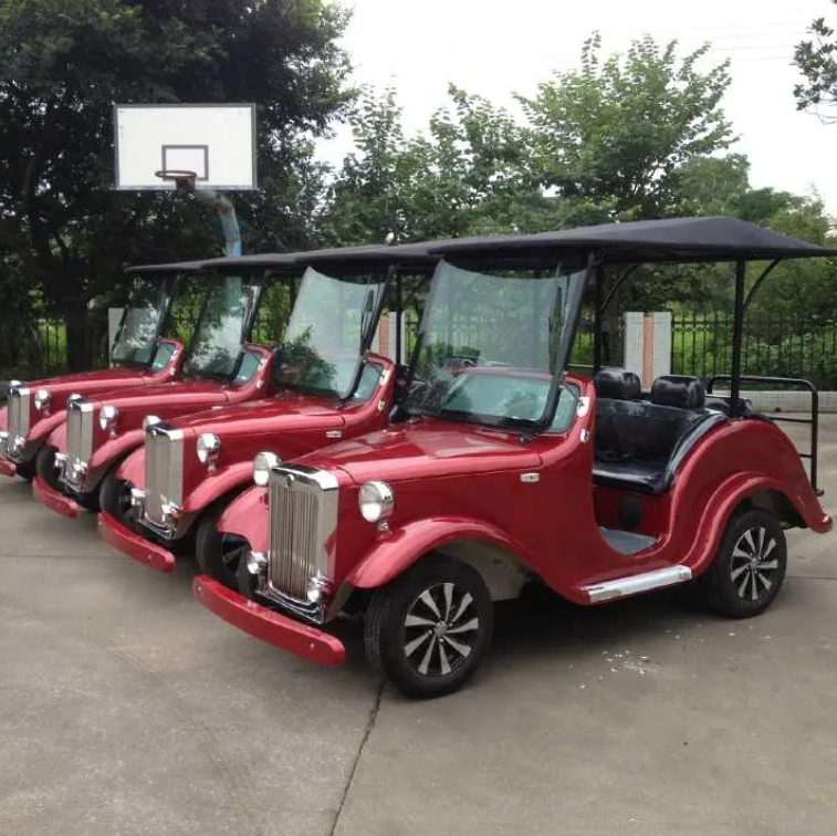 Red golf carts parked in a row outdoors with trees and a basketball hoop in the background.
