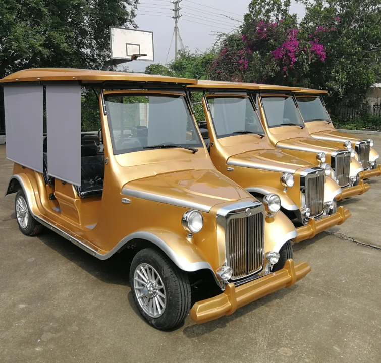 Three gold golf carts parked in a row on a concrete surface with trees and a basketball hoop in the background.