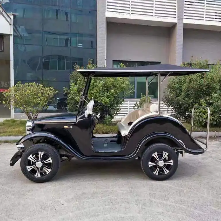 Black golf cart on a paved surface with a building in the background