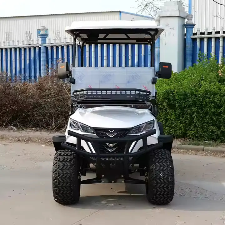 White off-road vehicle on a paved surface with a blue and white building in the background.