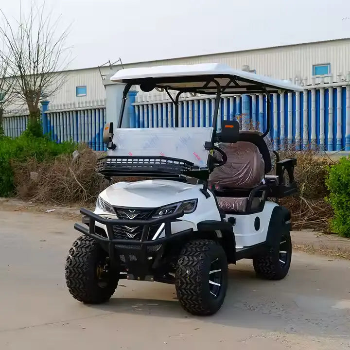 White golf cart with black tires on a paved surface, with a building and trees in the background.