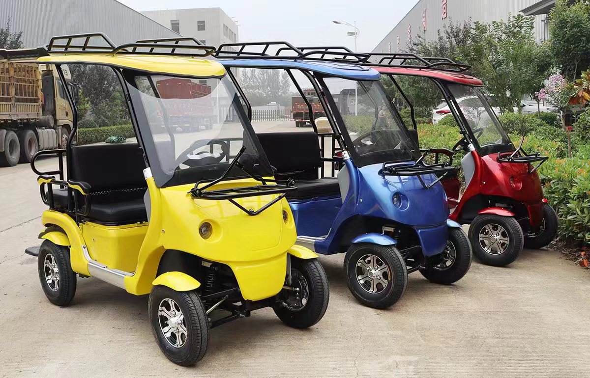 Three colorful electric carts parked on a concrete surface with a building and trees in the background.