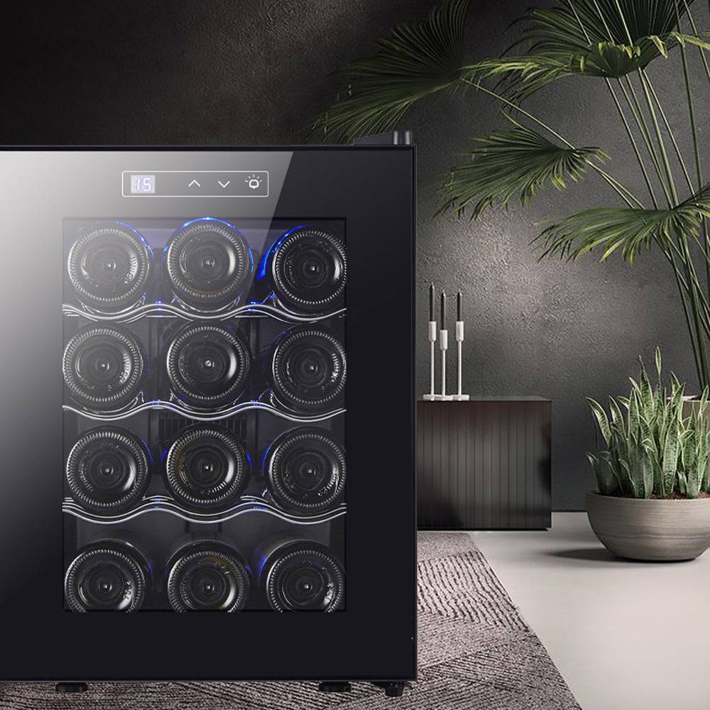 Black wine cooler with glass door displaying wine bottles in a modern interior setting.