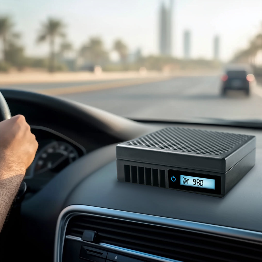 Car dashboard with a digital device displaying '980' on a blurred road background