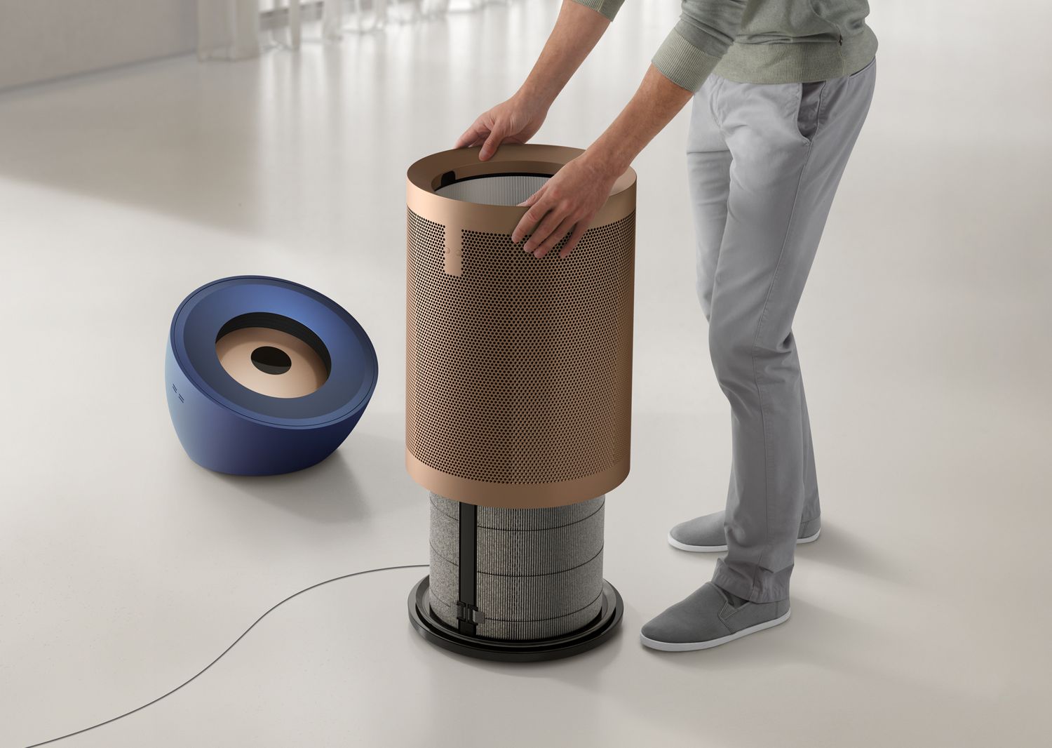 Person interacting with a cylindrical device on a white floor.